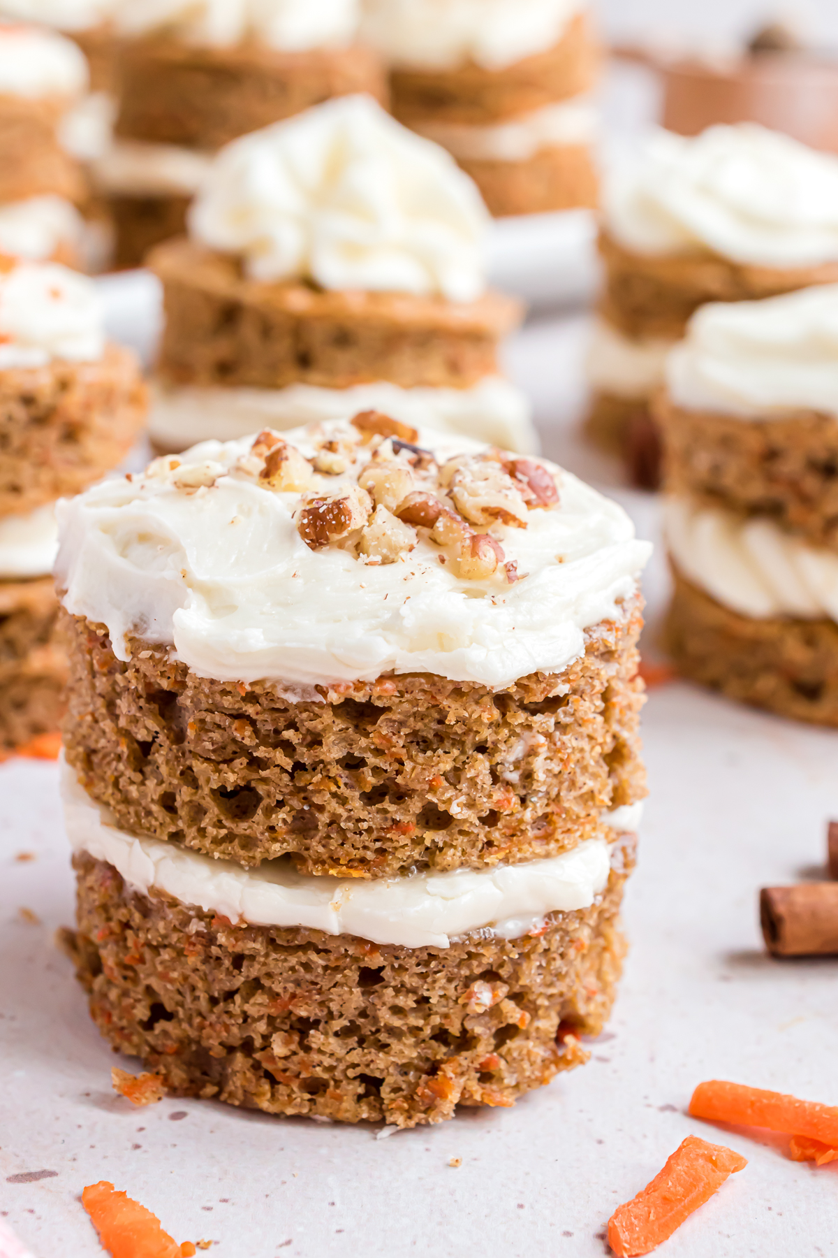 A double-layer mini carrot cake topped with chopped pecans