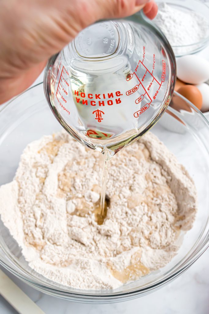 Photo of oil being poured into a mixing bowl on top of dry ingredients.