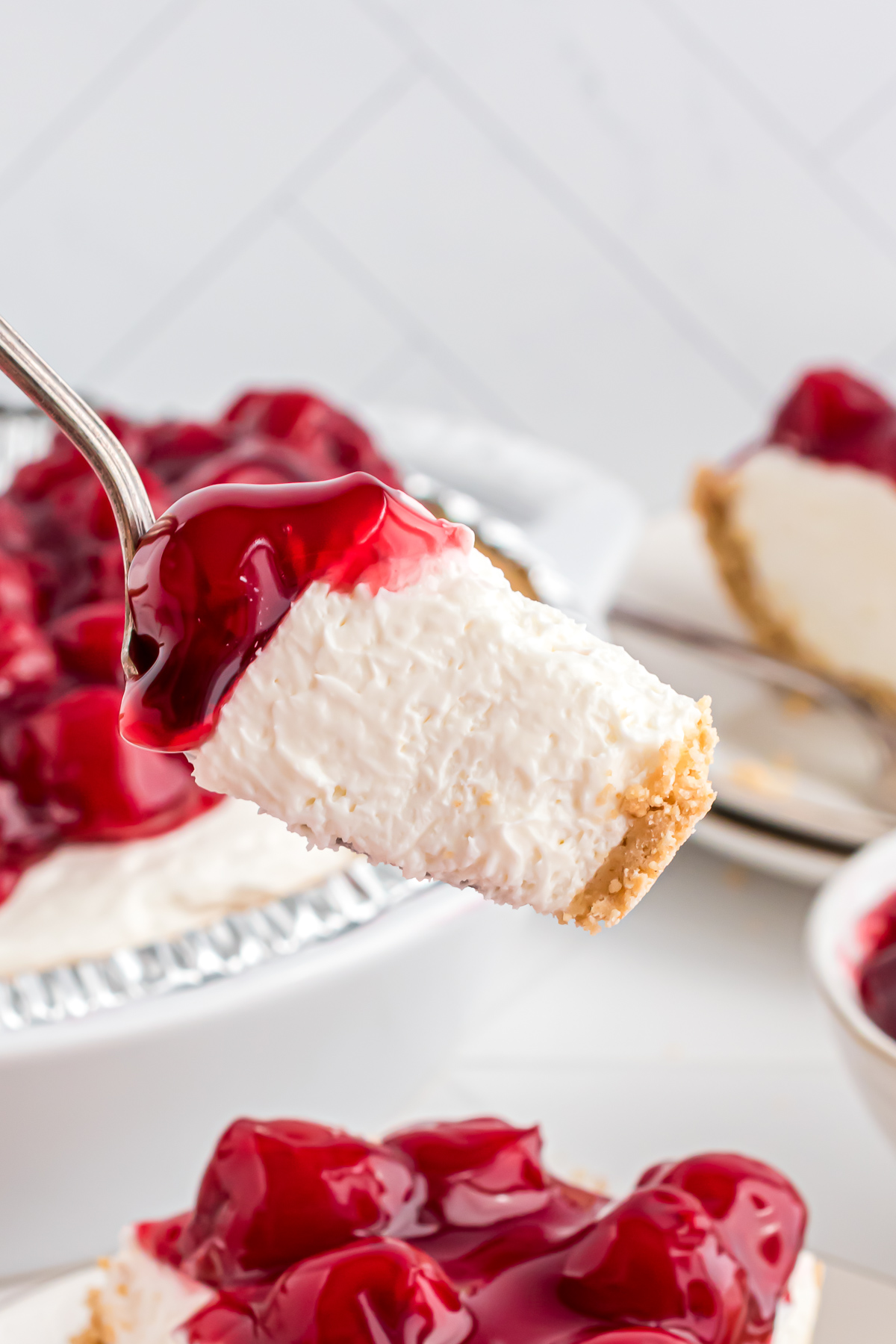 A bite of cherry cheesecake loaded onto a fork.