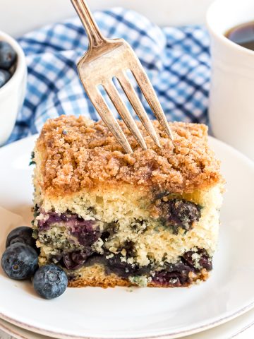 Blueberry Coffee Cake on a plate with a fork getting a bite out of the corner.