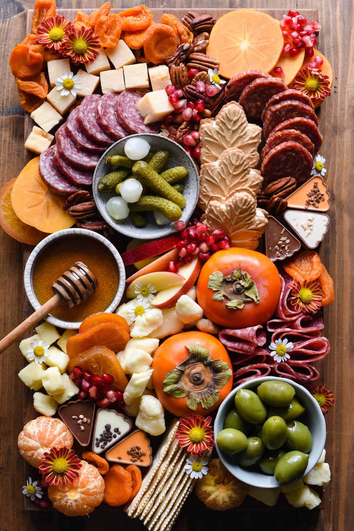 A fall themed charcuterie board with meats, cheeses, and sweets.