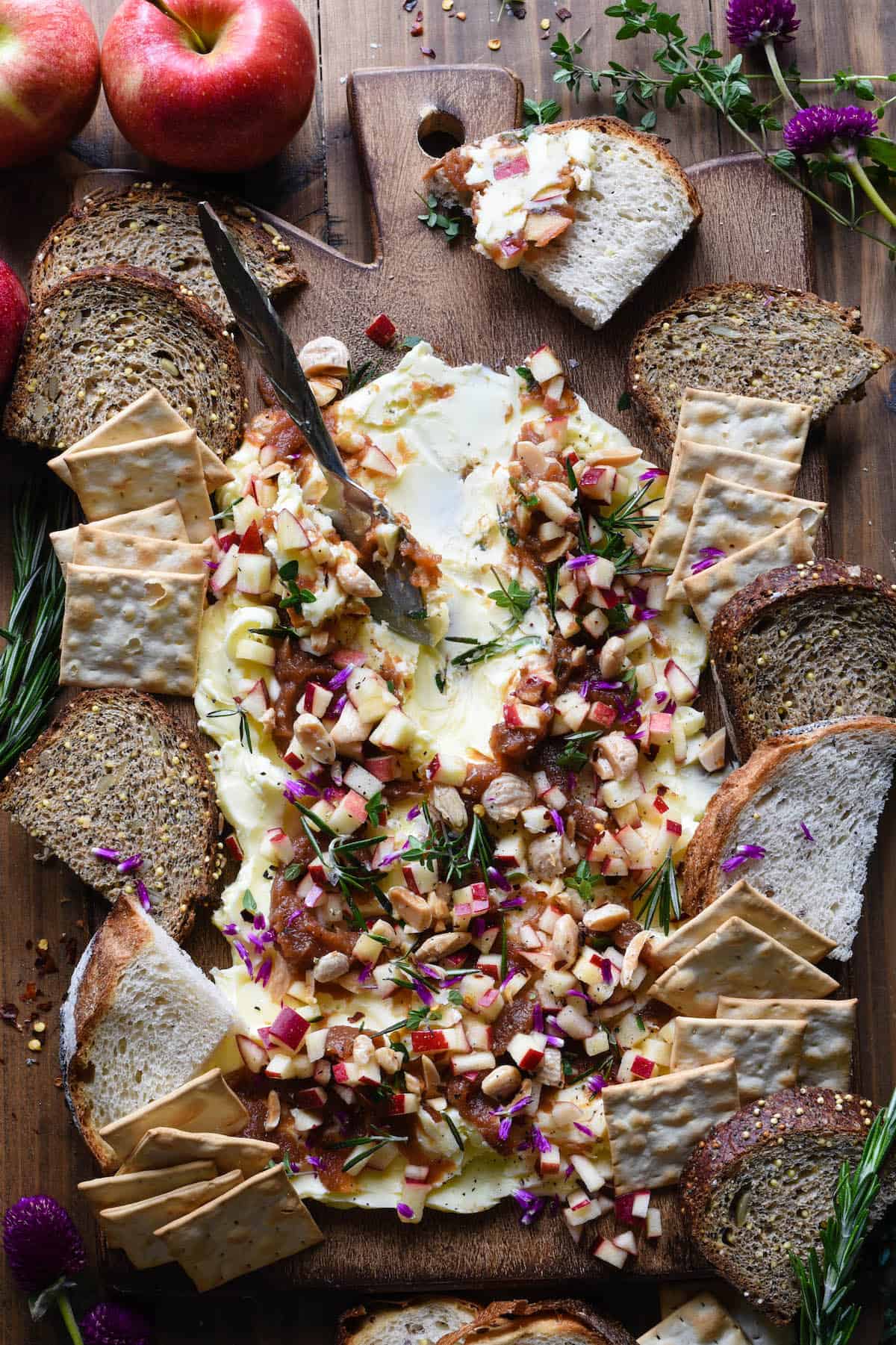An Autumn Butter Board topped with delicious fall ingredients like apple butter, herbs and nuts.