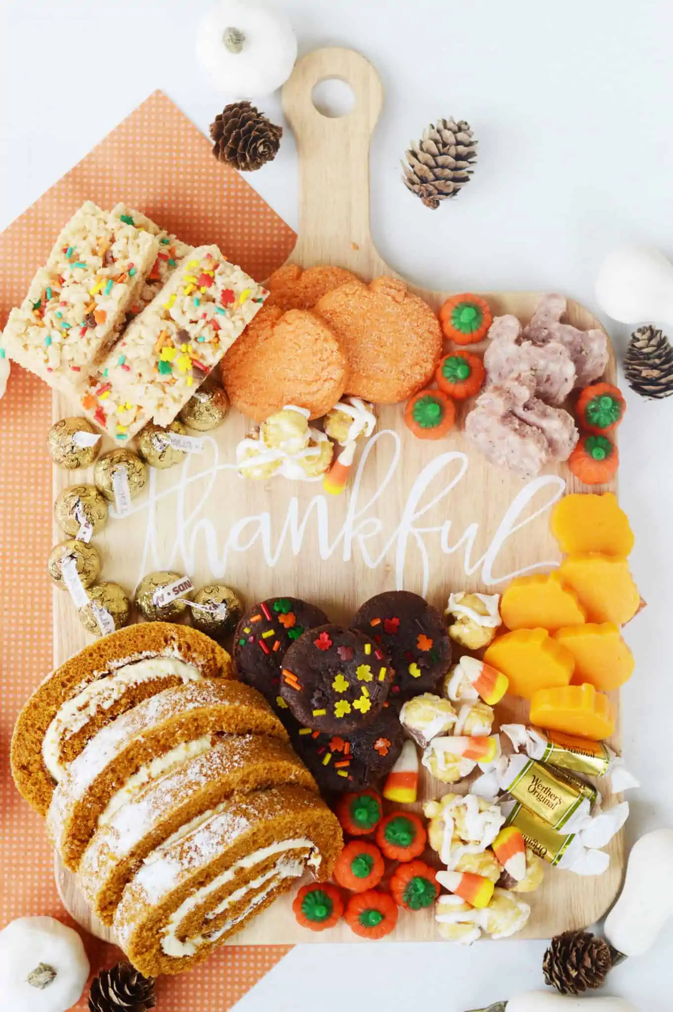 A dessert charcuterie board featuring pumpkin rolls, pumpkin cookies, fall rice krispie treats, candy corn and more.