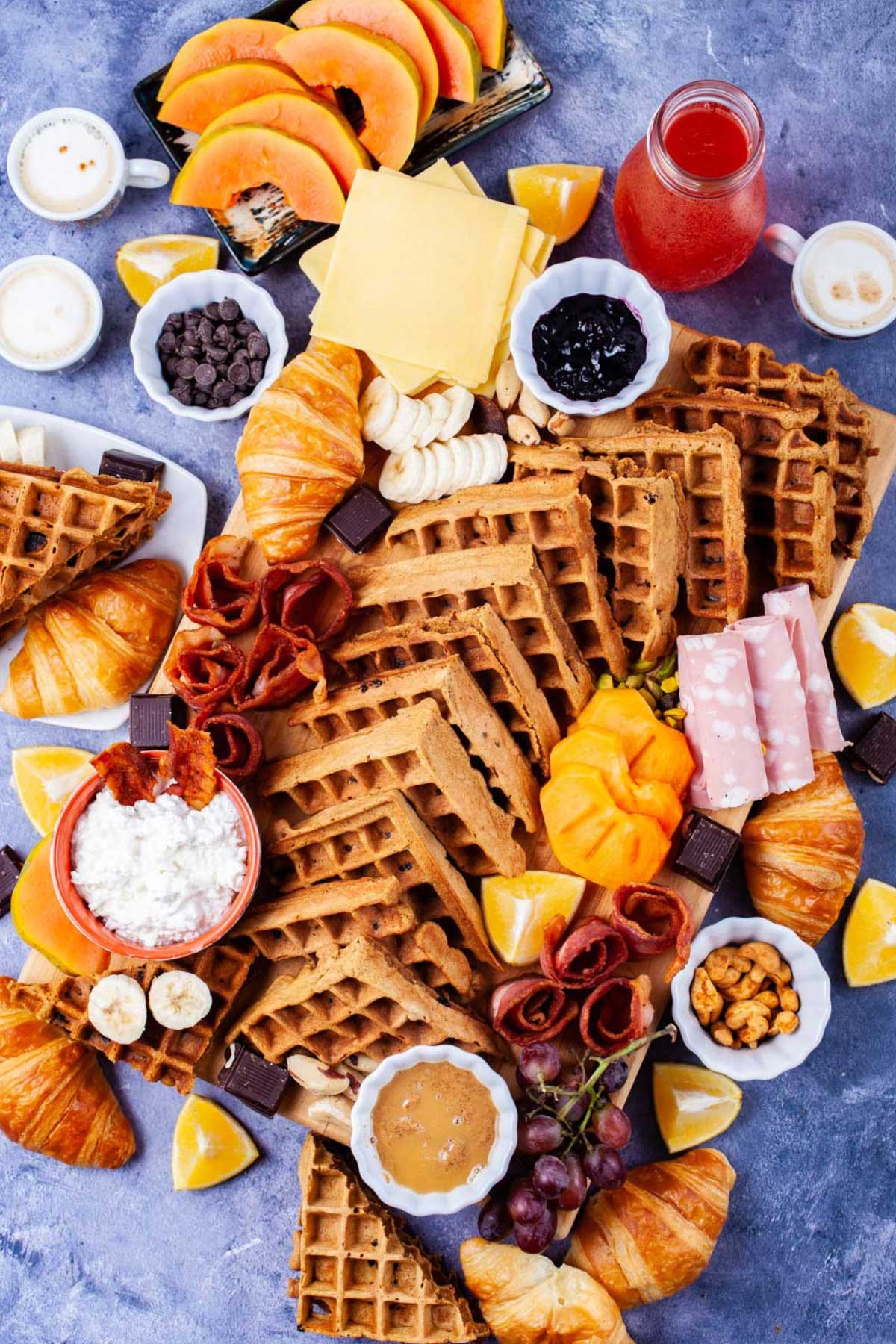 A waffle charcuterie board complete with all the toppings needed to dress them up.