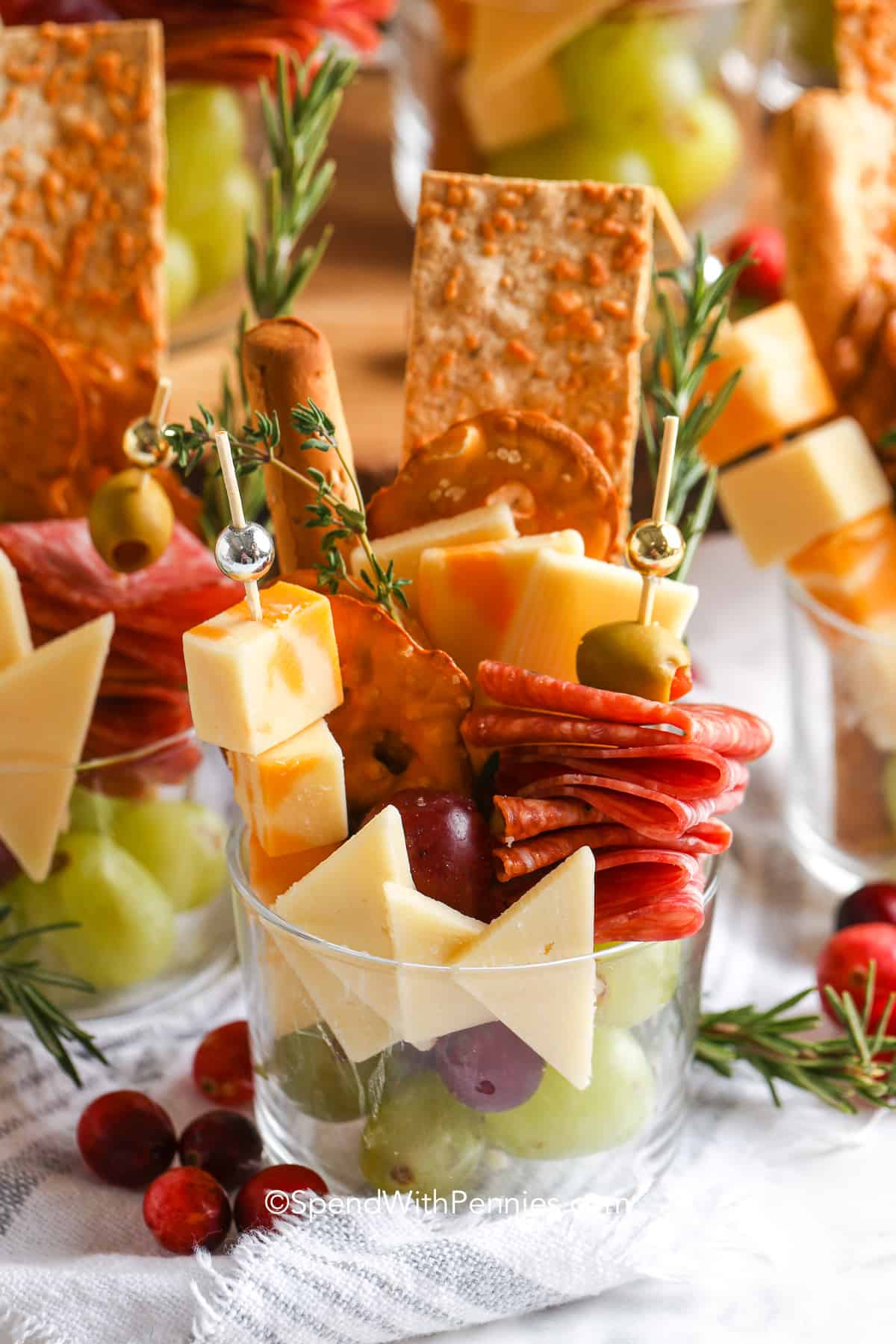 A different way to do a charcuterie board by putting the meat and cheese on a cocktail skewer and adding the ingredients to a plastic cup.