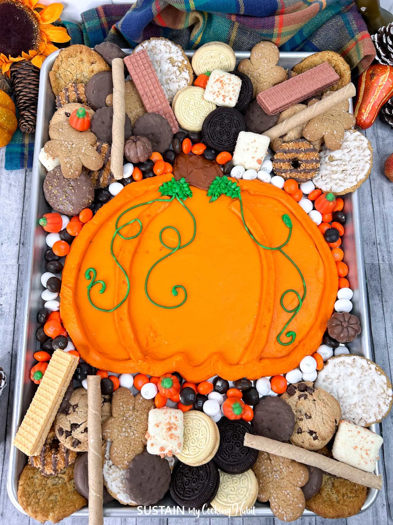 A dessert charcuterie board with a buttercream icing pumpkin perfect for dipping your favorite cookies.
