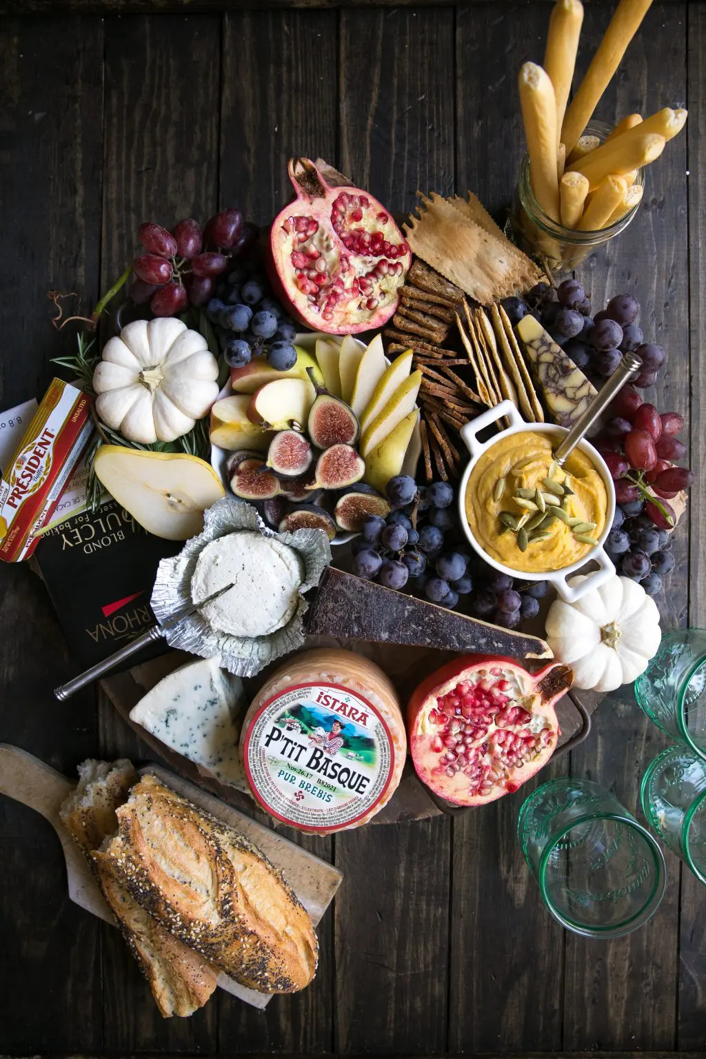 A fall cheese board with fruit and crackers.