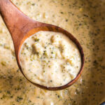 A ladle of broccoli cheese soup.