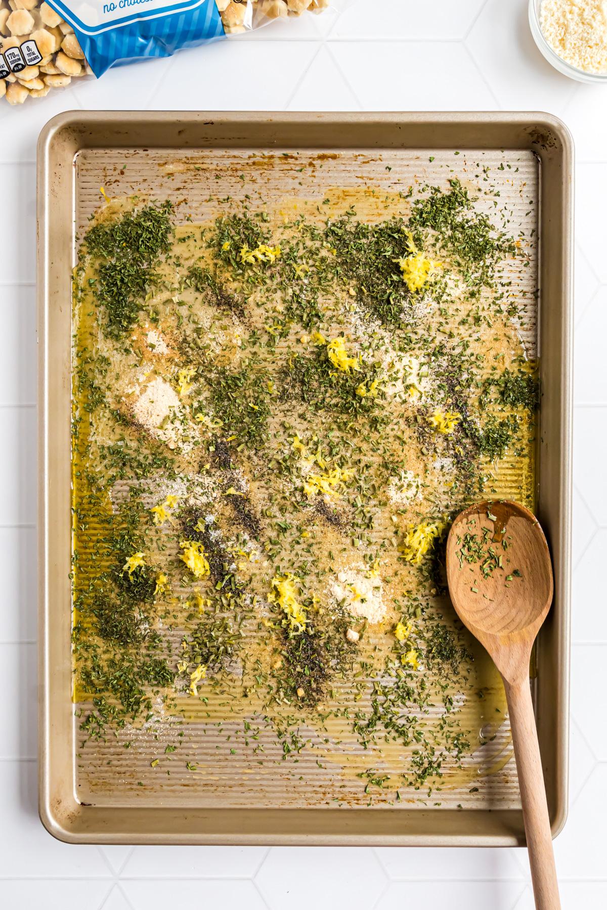 The next step in making the soup crackers includes combining the spices on the sheet pan.