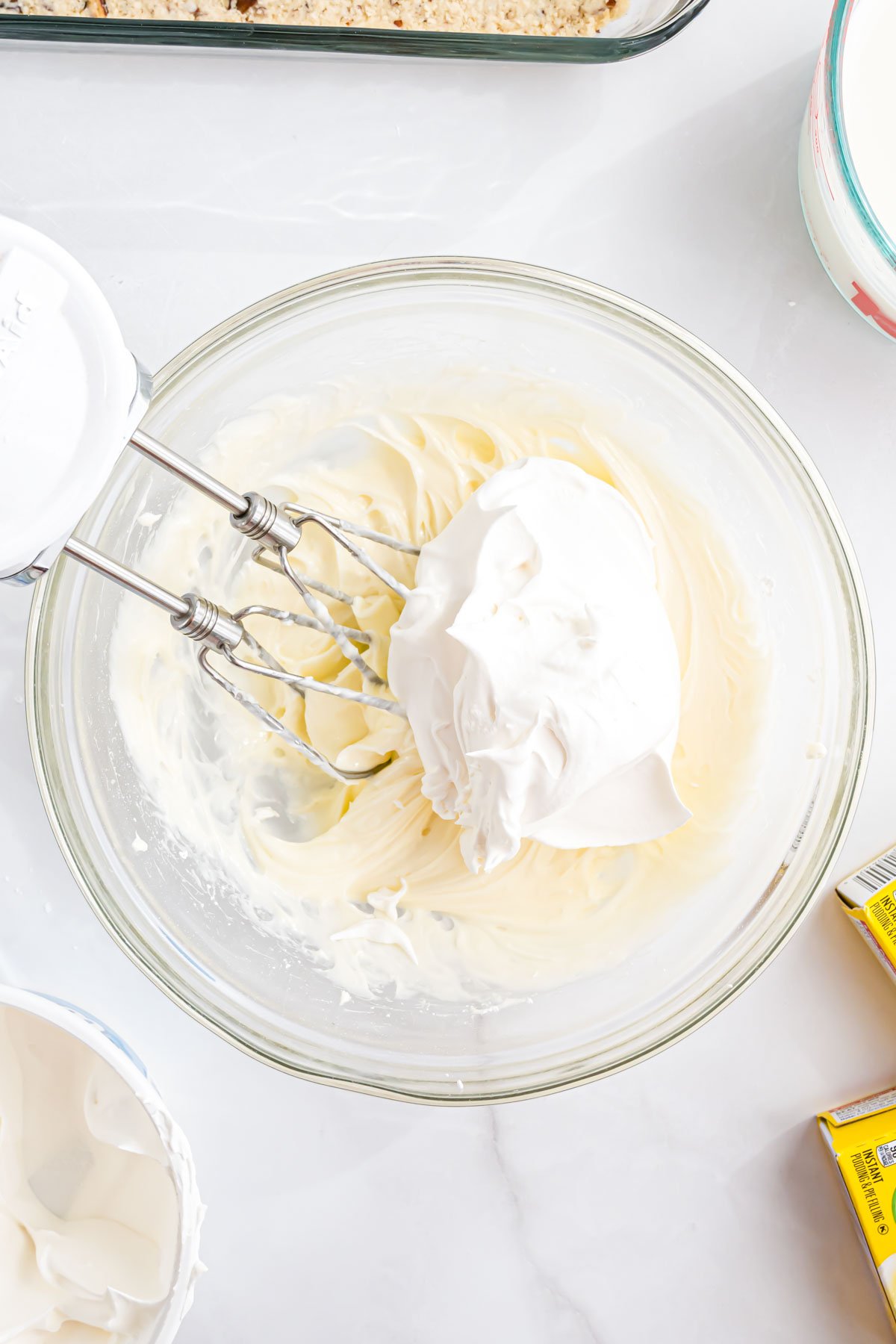 A large mixing bowl with the cream cheese and Cool Whip mixture in it.