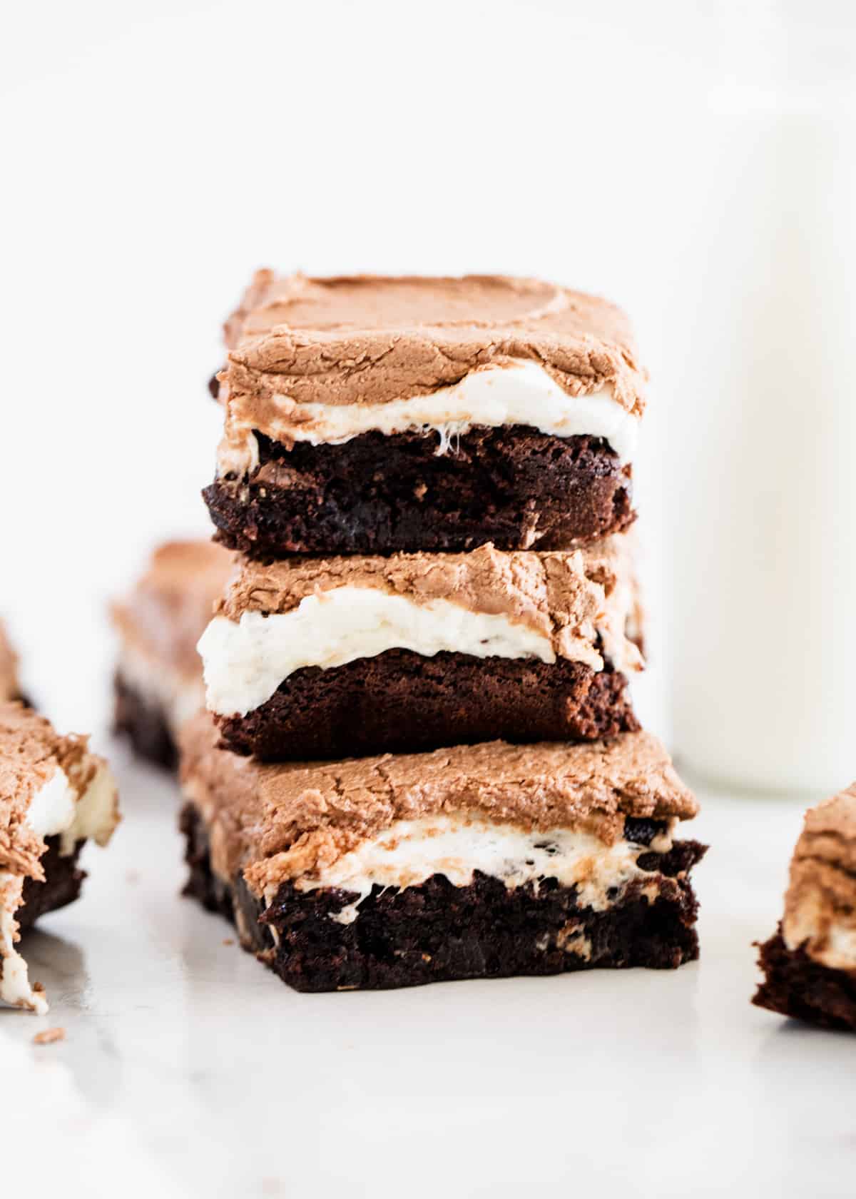 A stack of three brownies with marshmallow and chocolate topping.