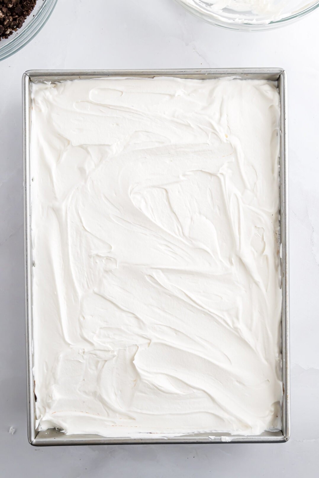 The ice cream dessert with the layer of Cool Whip spread on top of it.