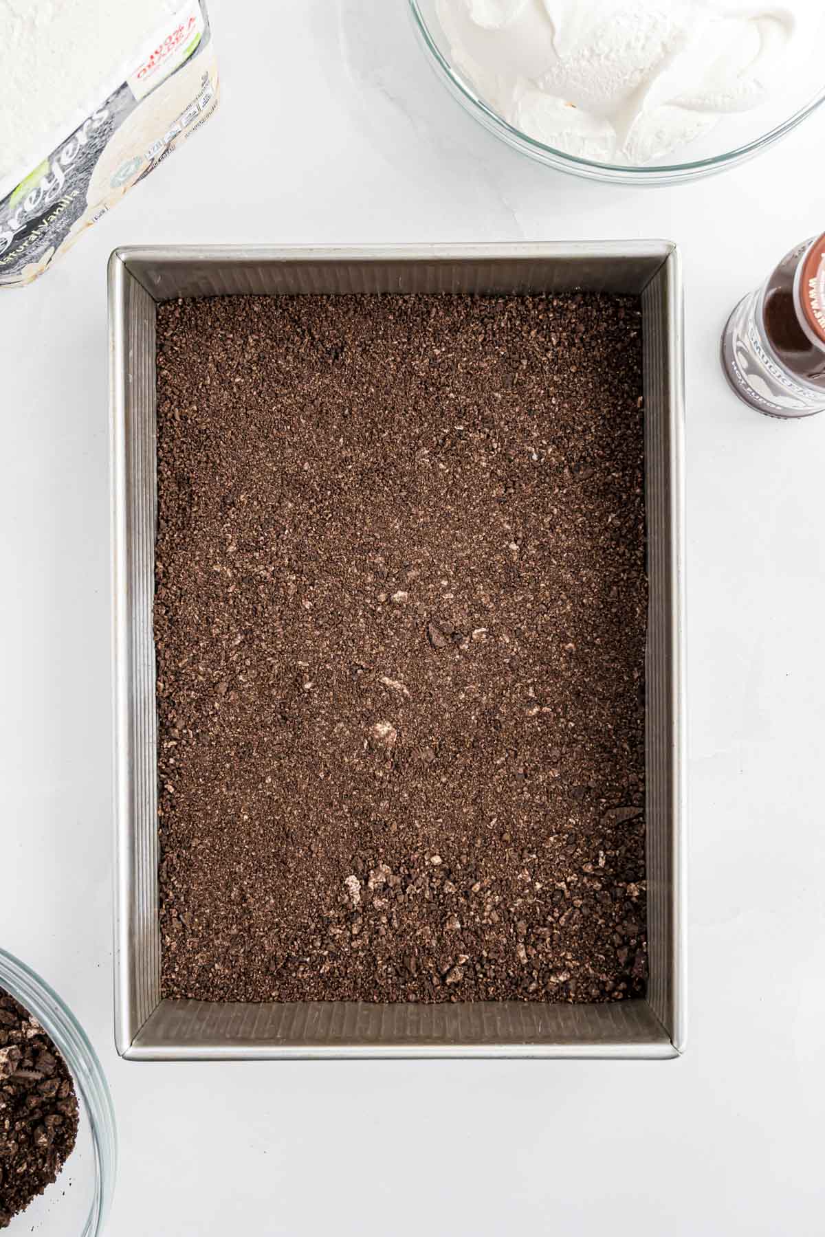 Crushed Oreos pressed into the bottom of a 9" x 13" in an even layer.