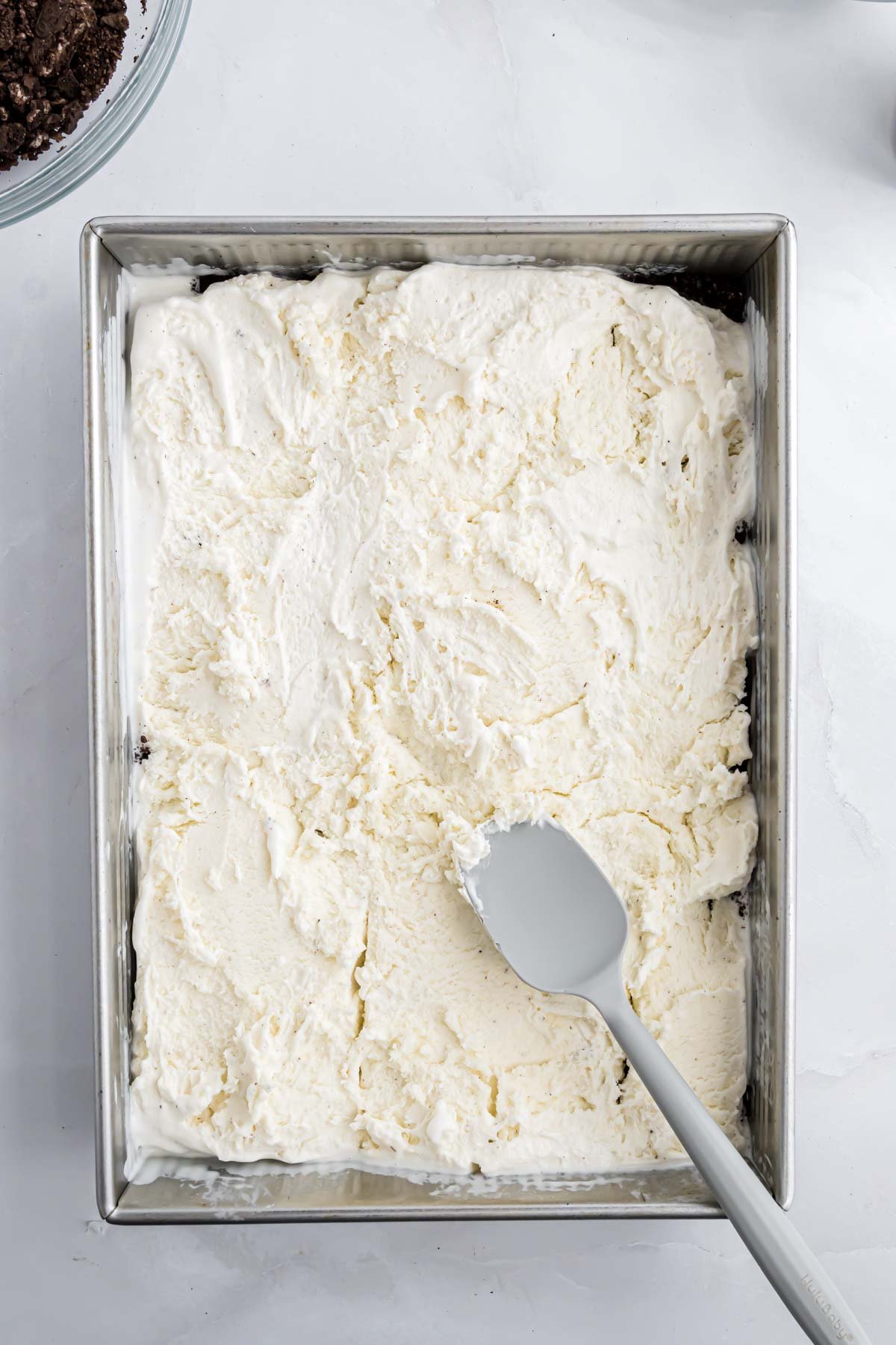 Vanilla ice cream layered evenly in the 9" x 13" pan.
