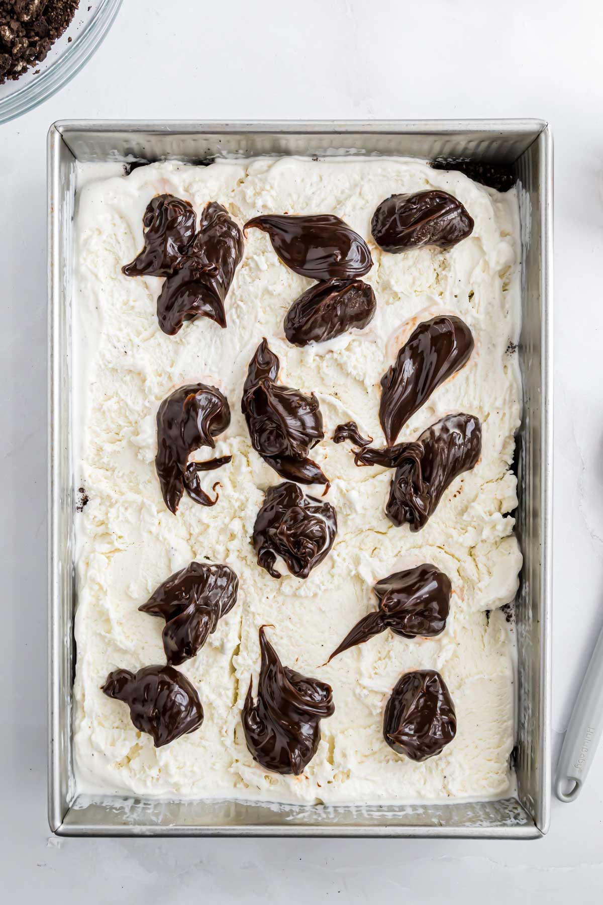 The ice cream dessert with dollops of hot fudge sauce on top of it.
