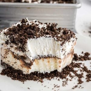 A piece of Oreo Ice Cream Dessert with a bite taken from the corner to reveal the layers of the cake.