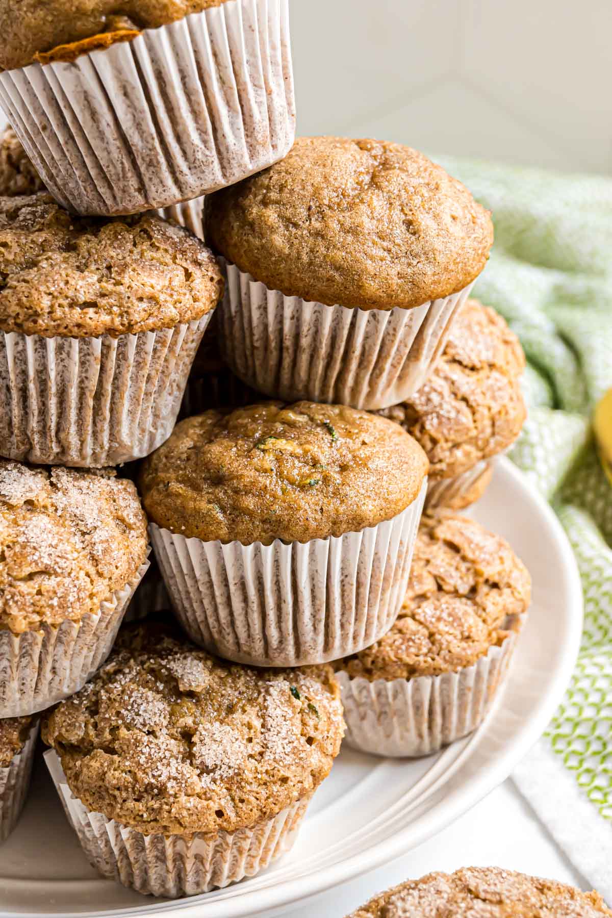 A plate of banana zucchini muffins, some with cinnamon sugar topping and some plain.