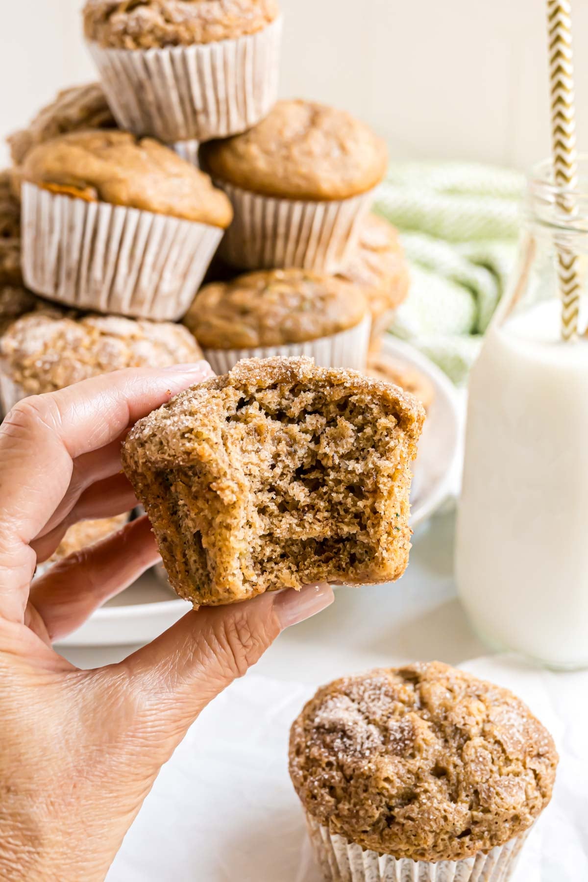 A zucchini banana muffin that has a bite taken out of it revealing an inside tender crumb texture.