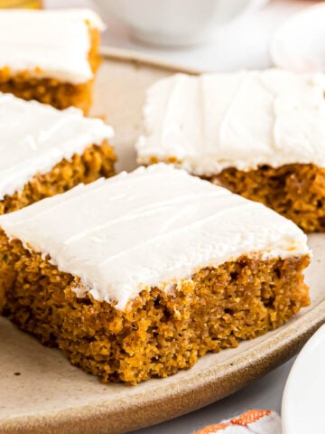 Pumpkin Bars with cream cheese frosting on a serving plate.