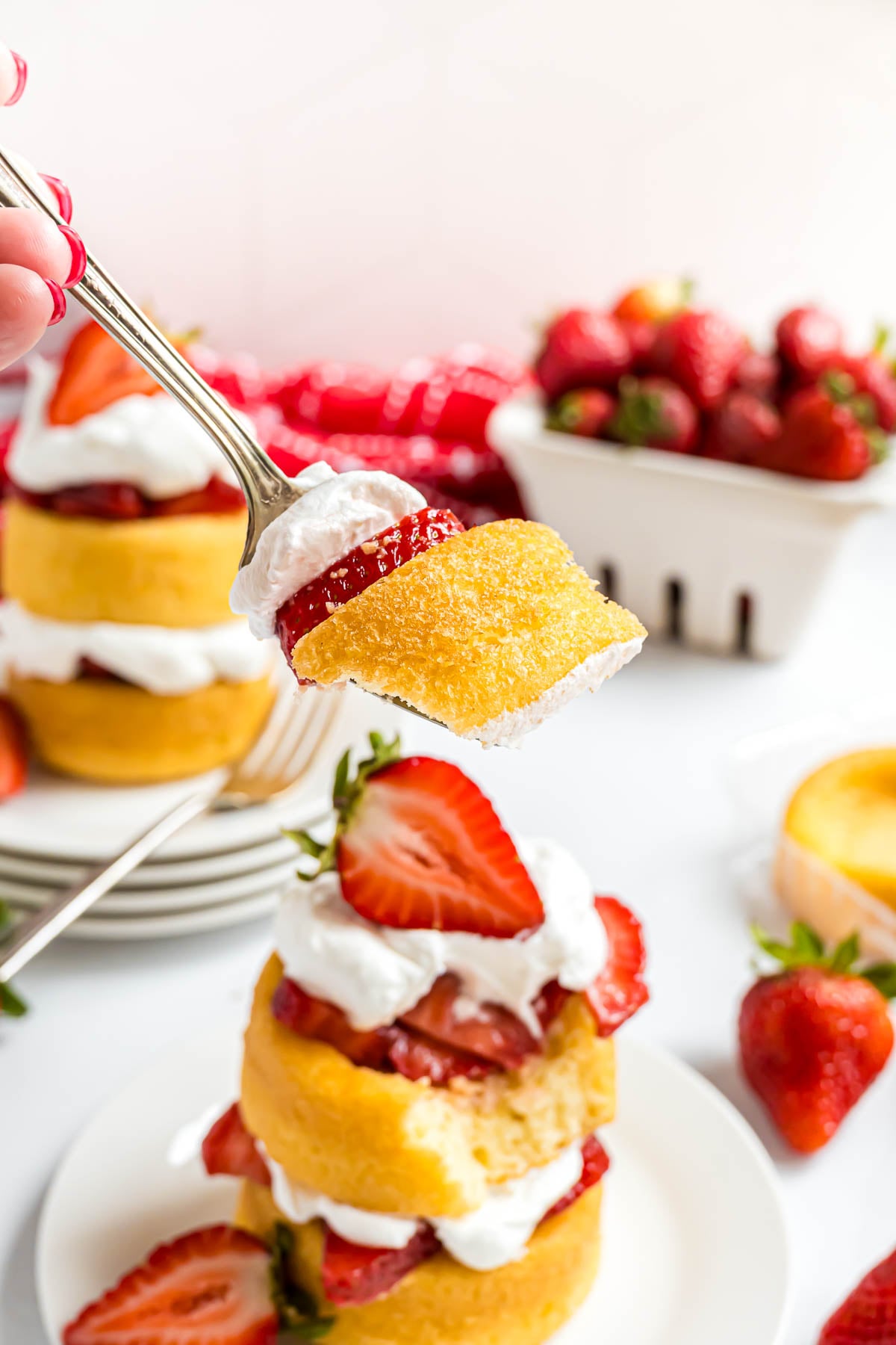 A bite of strawberry shortcake on a fork.