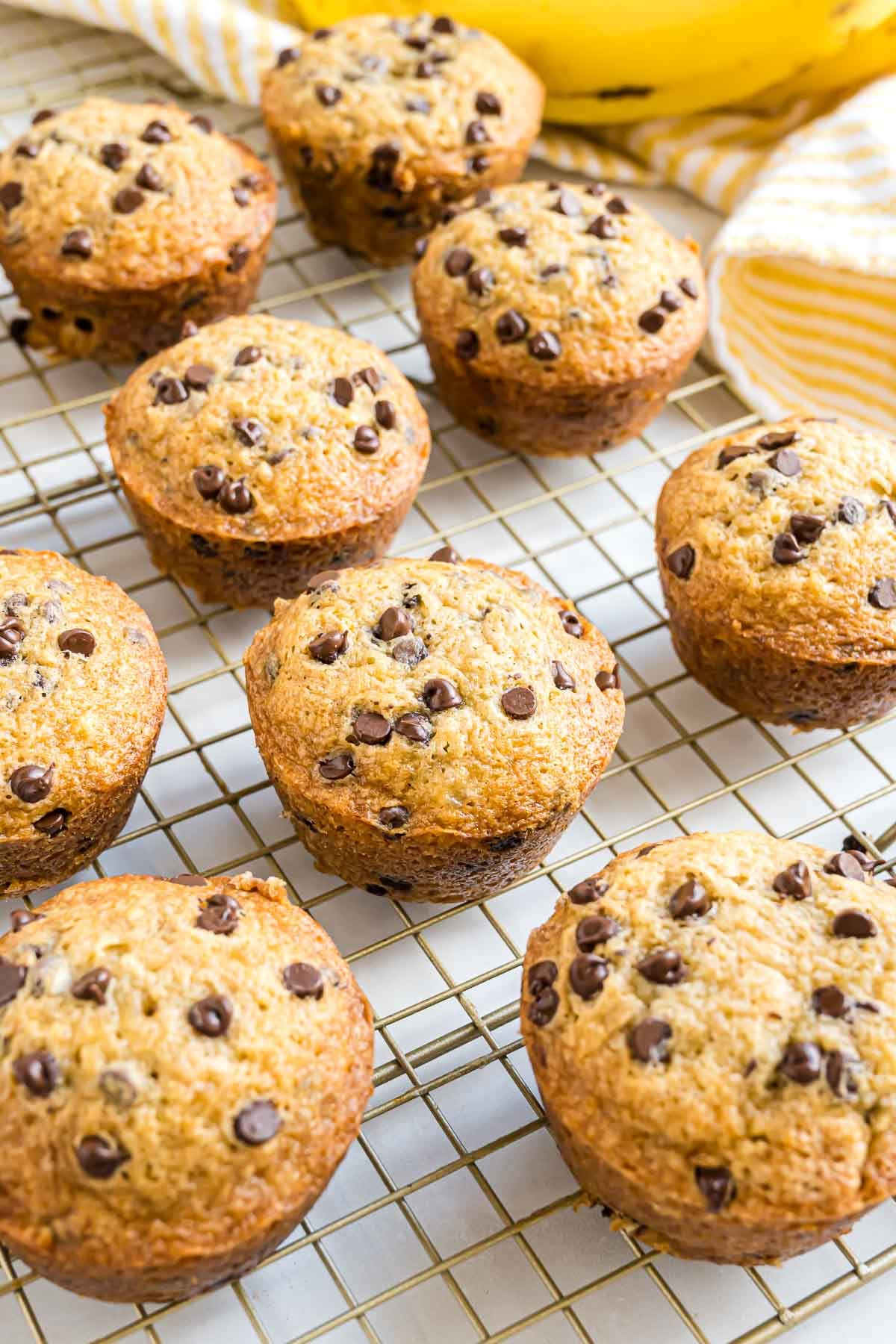 Freshly baked banana chocolate chip muffins on a cooling rack.