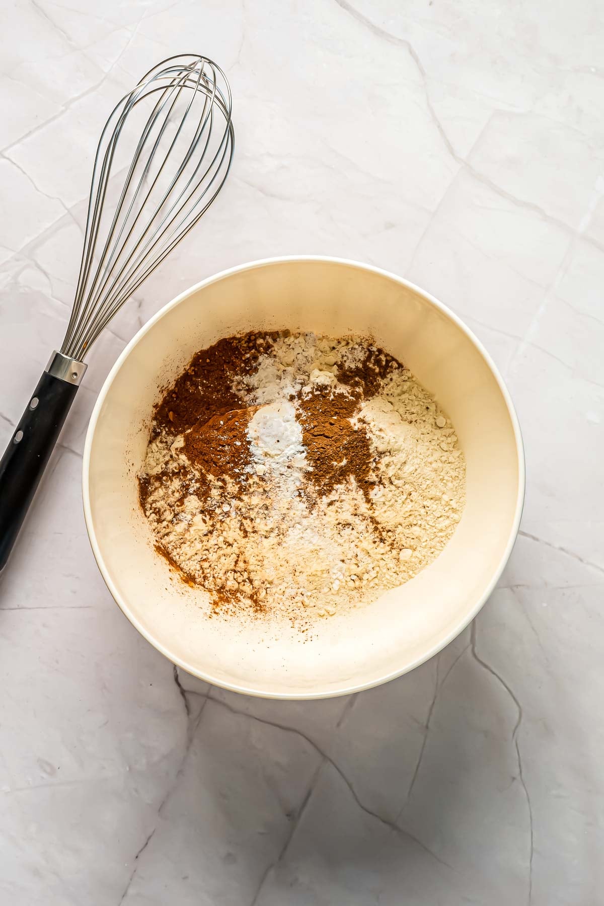Combining the dry ingredients for the carrot cake in a large mixing bowl.