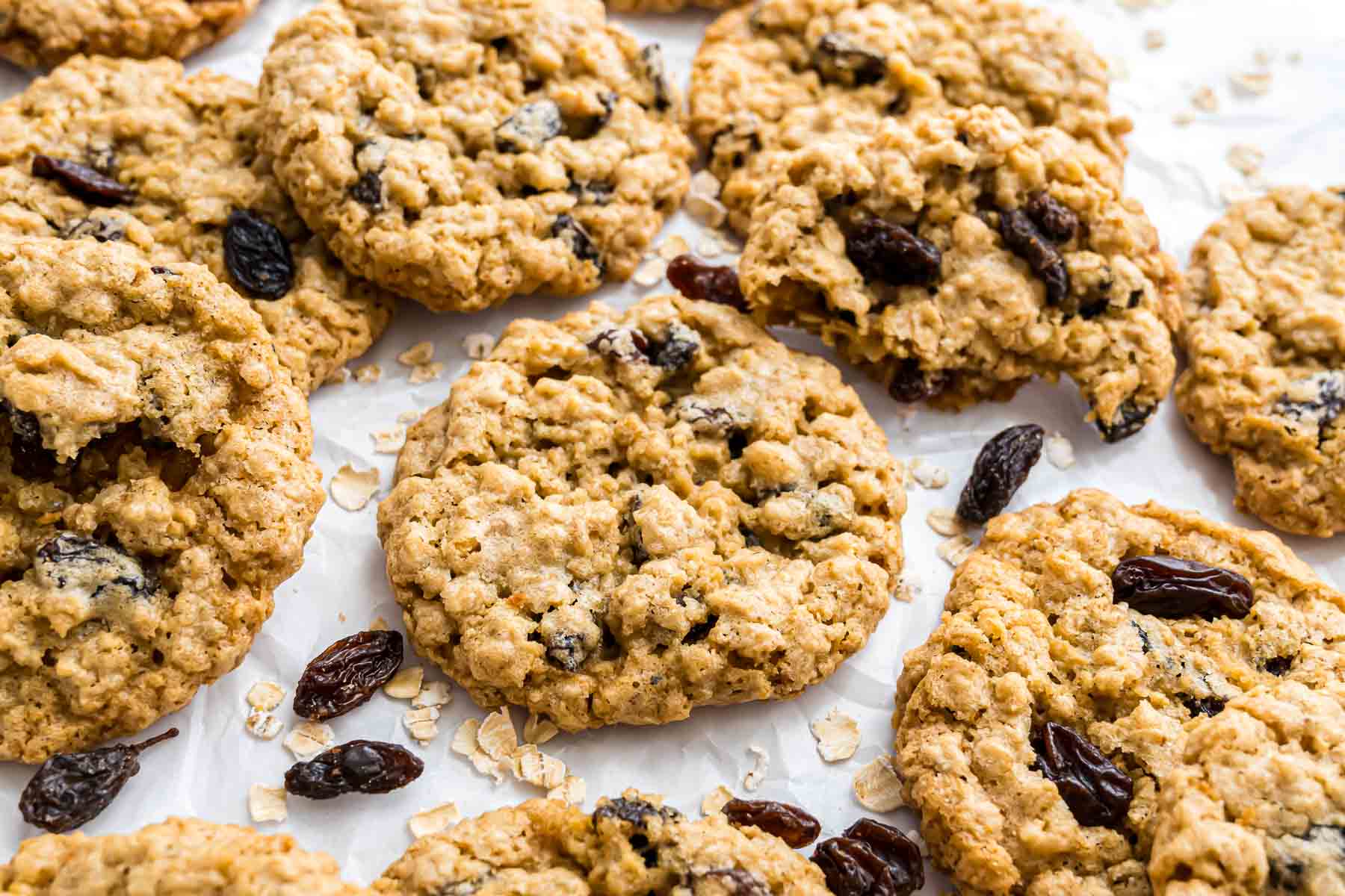 Oatmeal raisin cookies on a baking sheet lined with parchment right after baking.