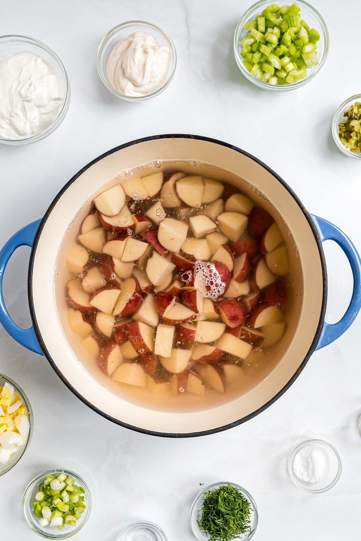 The potatoes for the salad, cut into cubes, in a large pot of cold water.