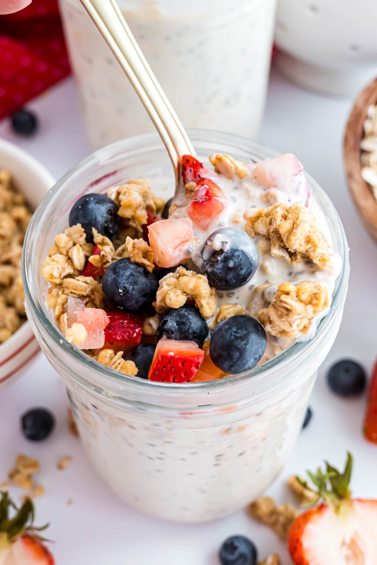 A pint jar with high protein overnight oats topped with berries and granola.