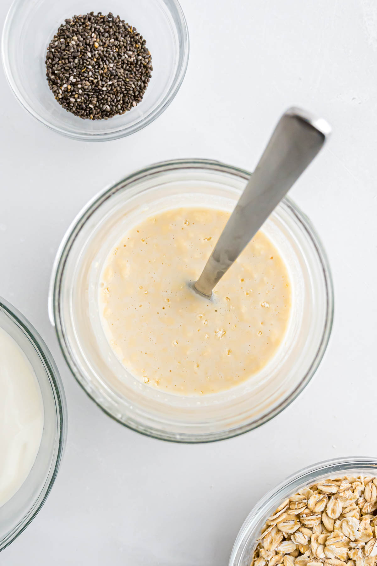 A jar with protein powder and milk mixed before adding the other ingredients for the overnight oats.